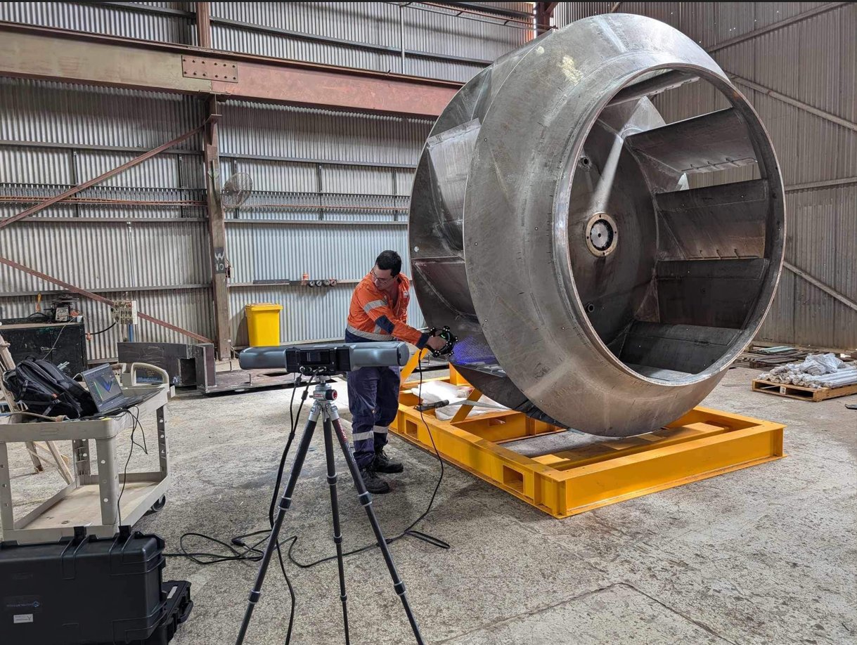 Technician 3D scanning large fan impeller in workshop
